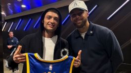 Foto que representa a Peso Pluma aparece por sorpresa en juego de la NBA; Stephen Curry le regala jersey de Warriors